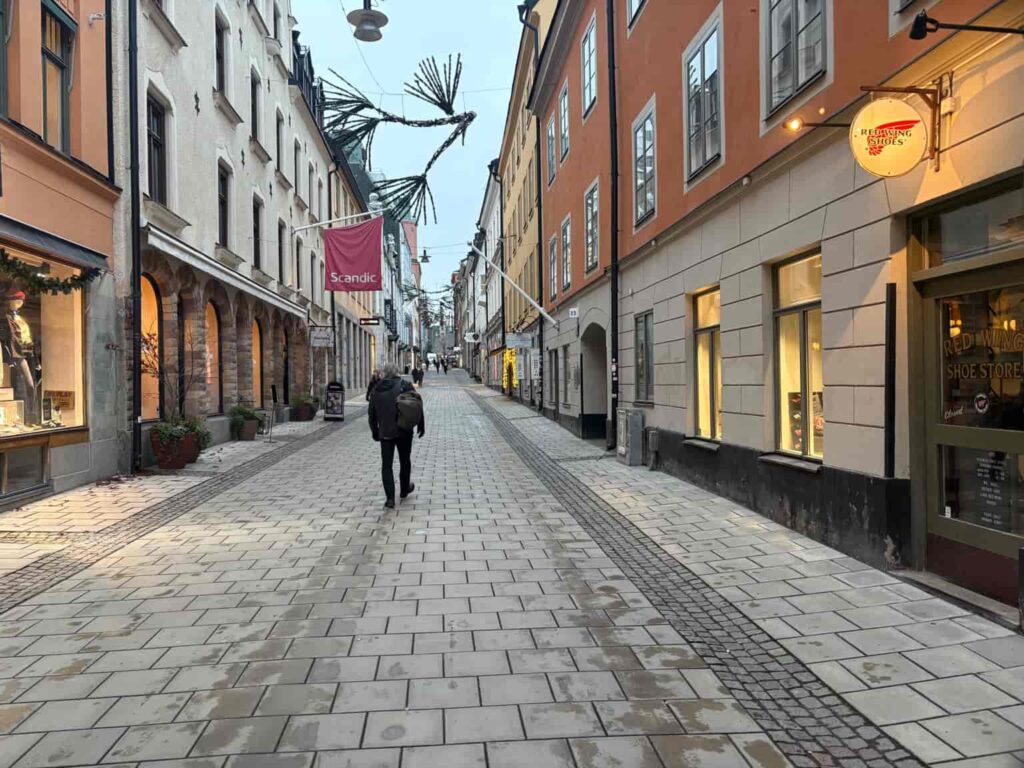 ストックホルム旧市街の静かな通りを歩く人。英語を使った旅行体験を記録した記事のアイキャッチ画像。