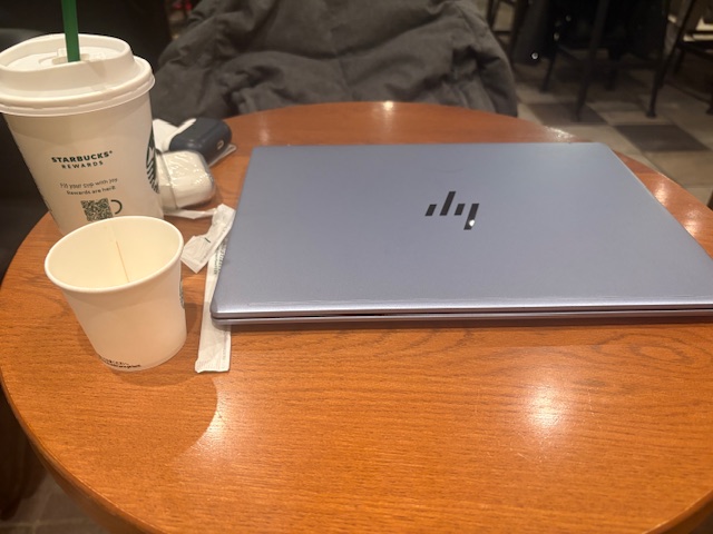 TOEIC Part5の復習で記憶が残らず、カフェでノートPCを前に考え込む学習者の机