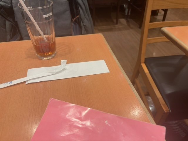 ドトールのテーブルにアイスティーとピンクの教材