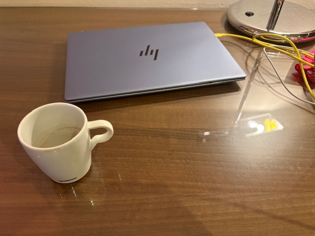 閉じたノートPCとコーヒーカップ