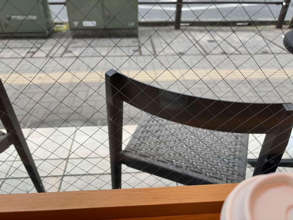 カフェの窓越しに見える椅子と外の景色