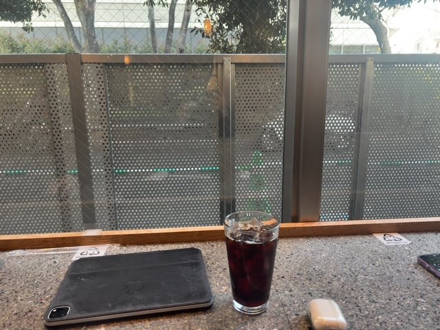 カフェの窓辺でiPadとアイスコーヒー
