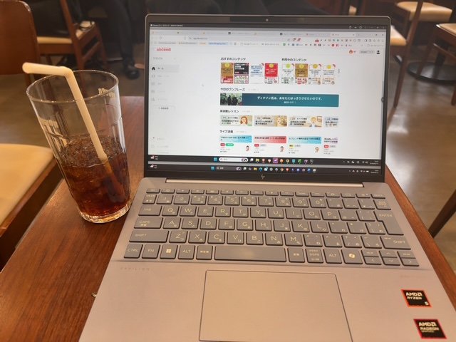カフェでラップトップを開いて英語学習サービスの画面を見ている